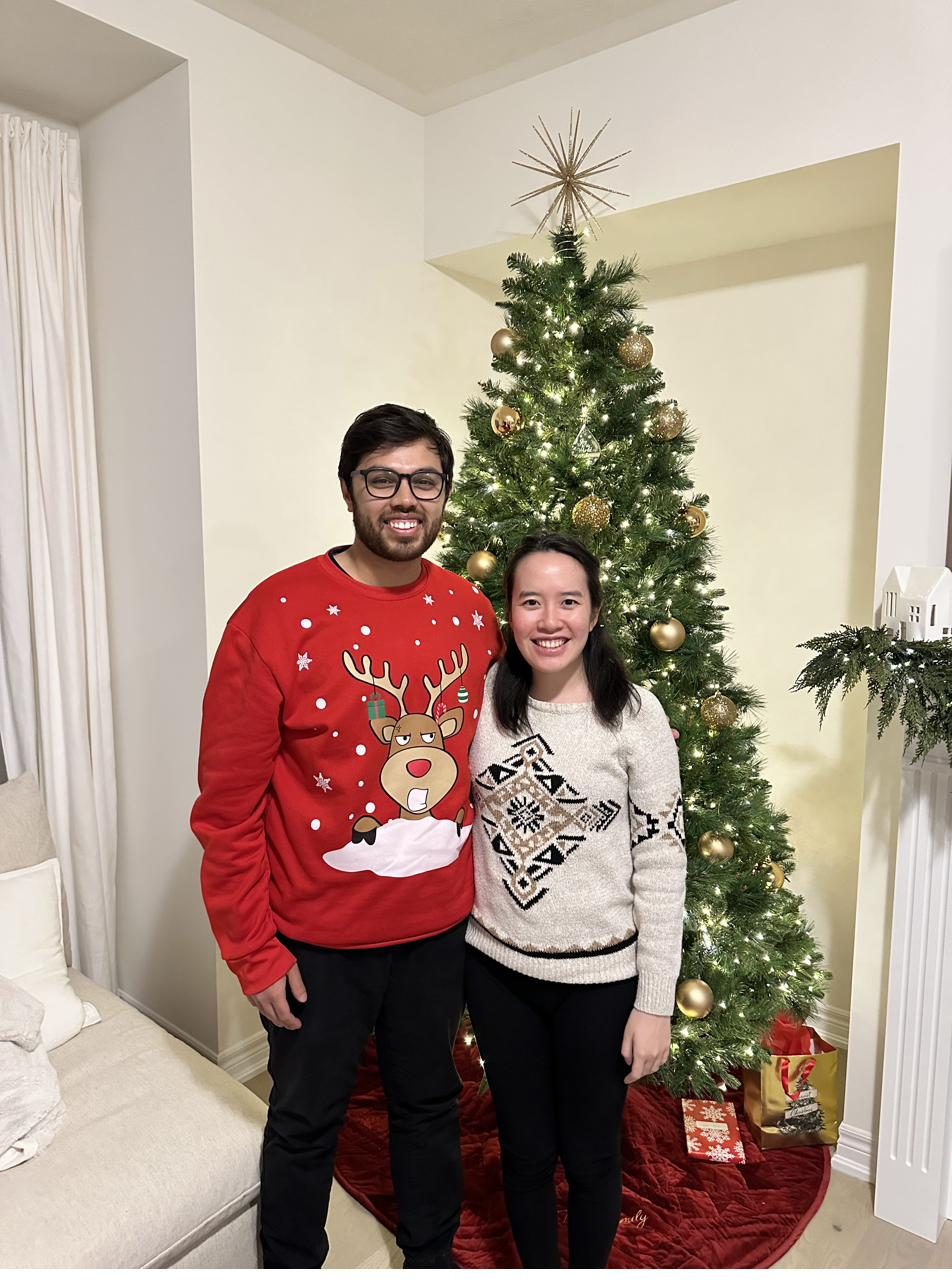 The couple in holiday sweaters by their Christmas tree