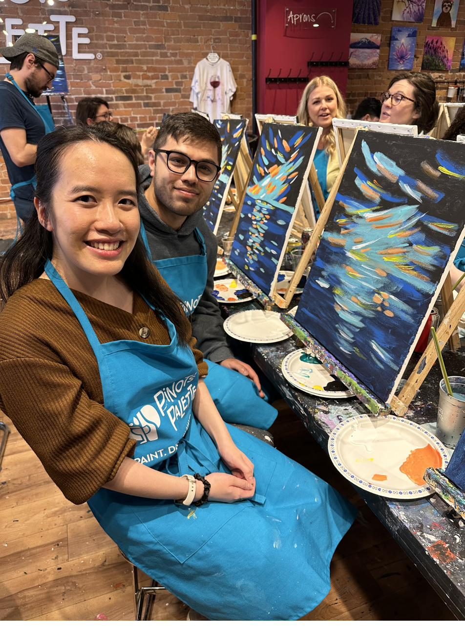 The couple at a paint night with their canvases